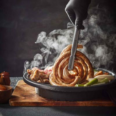 완성된 시그니처 곱창 메뉴를 집게로 들어 올리는 사진